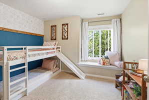 Bedroom featuring light colored carpet and baseboards
