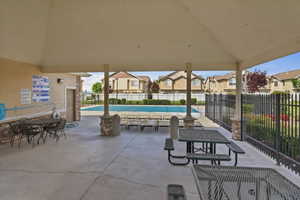 View of patio featuring a residential view, a community pool, and outdoor dining area