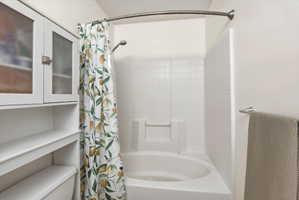 Full bath with shower / bath combo with shower curtain and toilet