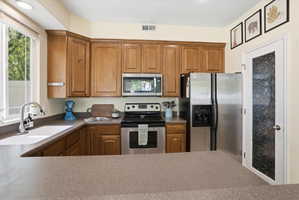 Kitchen with stainless steel appliances and wood finish cabinets