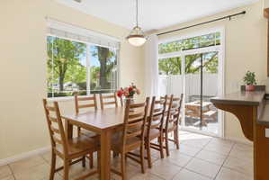 Dining space featuring light tile patterned floors and baseboards