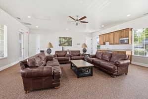 Living room with carpet, a ceiling fan, and recessed lighting