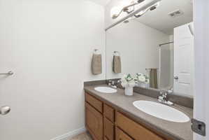 Bathroom featuring double vanity and a shower