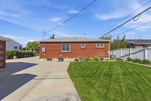 Rear view of property featuring brick siding and a chimney