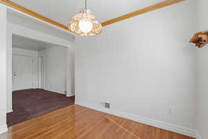 Unfurnished room with crown molding and light wood-style flooring
