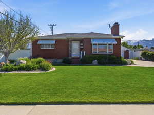 View of front of home with brick siding, a chimney, and a mountain view