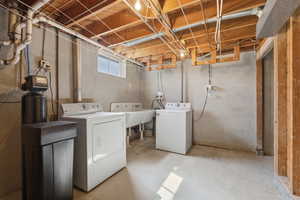Laundry area with unfinished concrete floors and washing machine and dryer