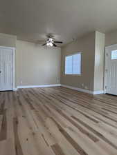 Dining room featuring light wood-style flooring, a ceiling fan, and a textured ceiling