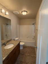 Bathroom with bathtub / shower combination, vanity, and a textured ceiling