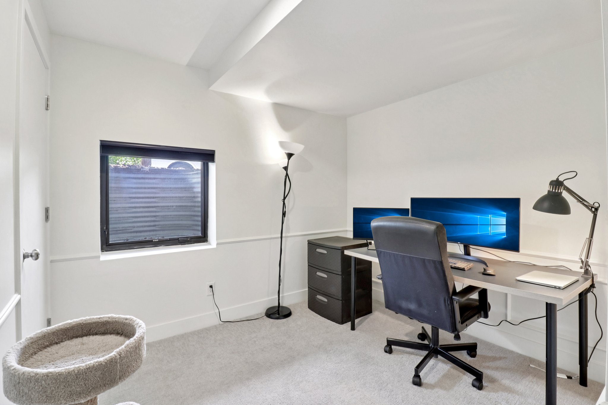 Office with light colored carpet and baseboards