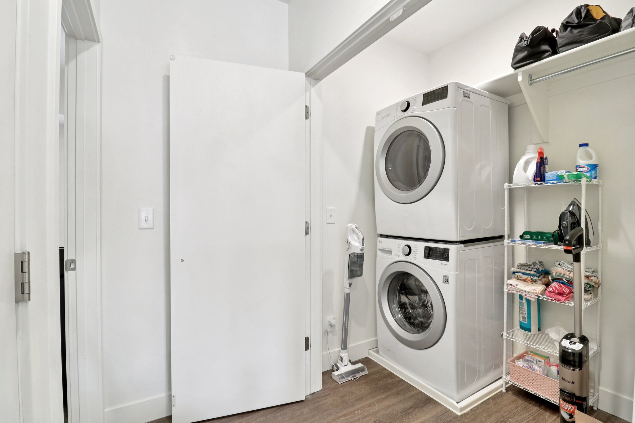 Laundry area featuring dark wood-style floors and stacked washer and clothes dryer