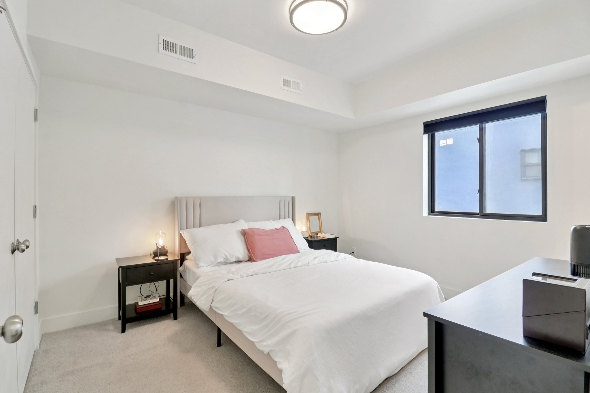 Bedroom with light colored carpet and baseboards