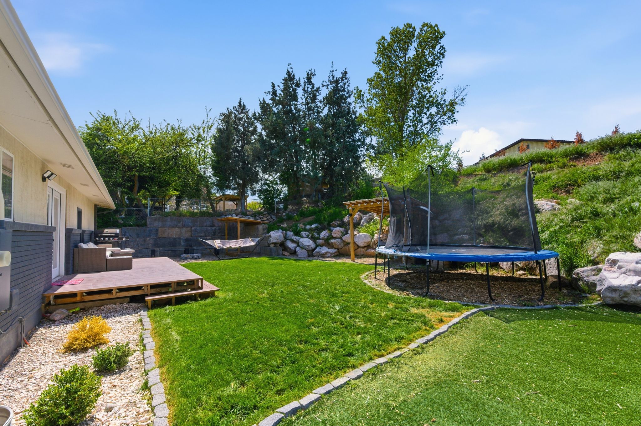 View of yard with a trampoline and a deck