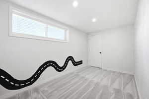 Room featuring a horizontal window with blinds, recessed lighting, and light gray carpet