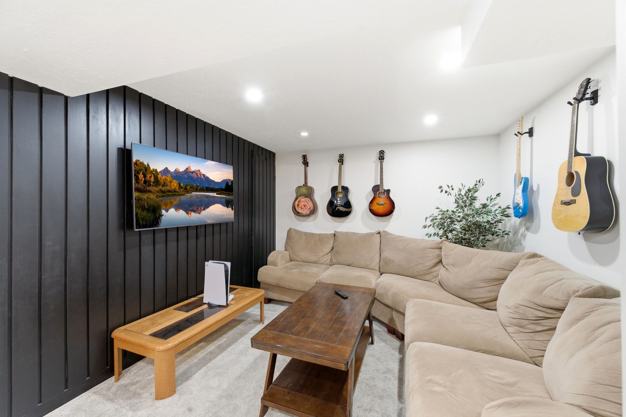 Living room with wooden walls, carpet flooring, and recessed lighting