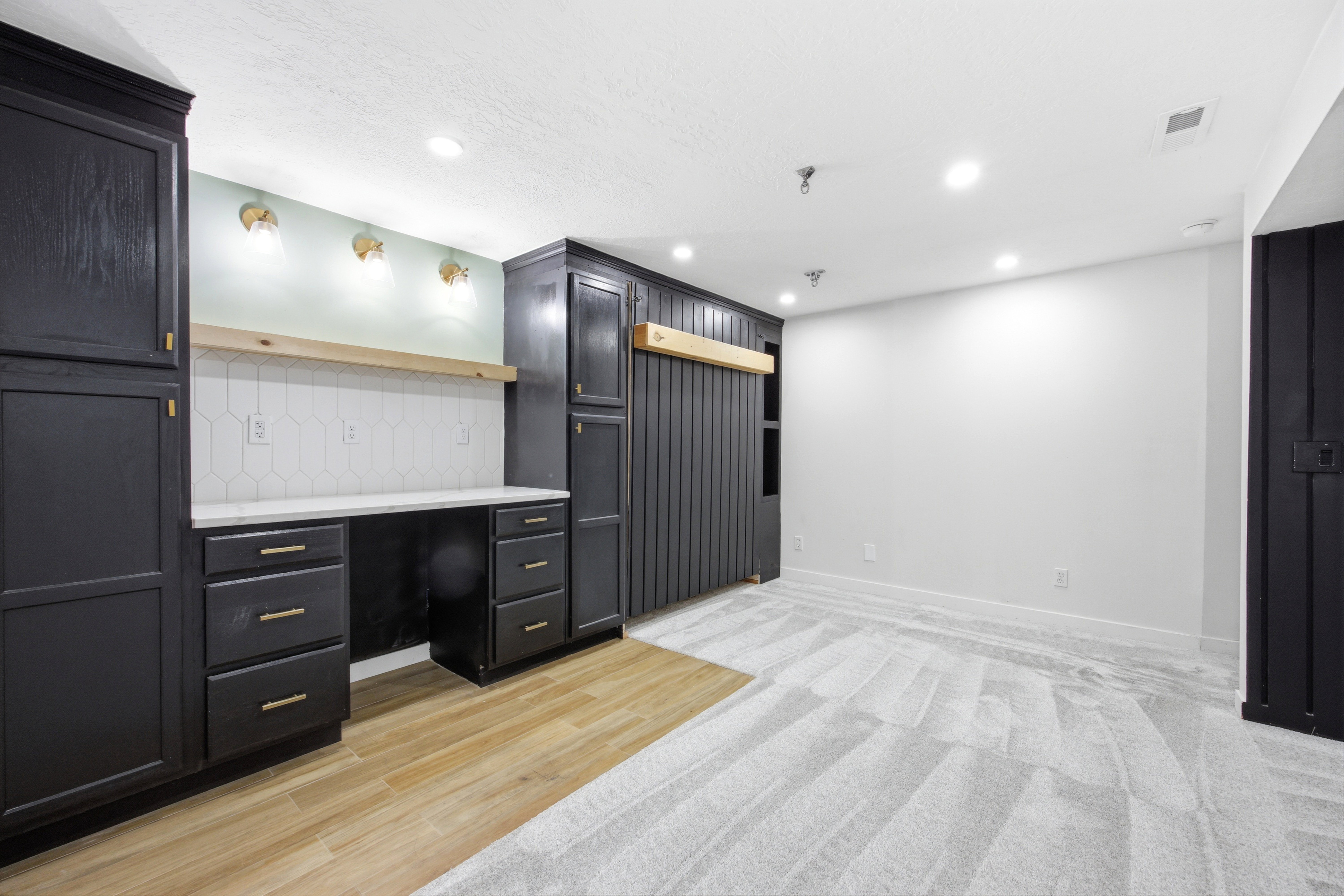Integrated desk space featuring dark cabinetry, a white countertop, and hexagonal tile backsplash