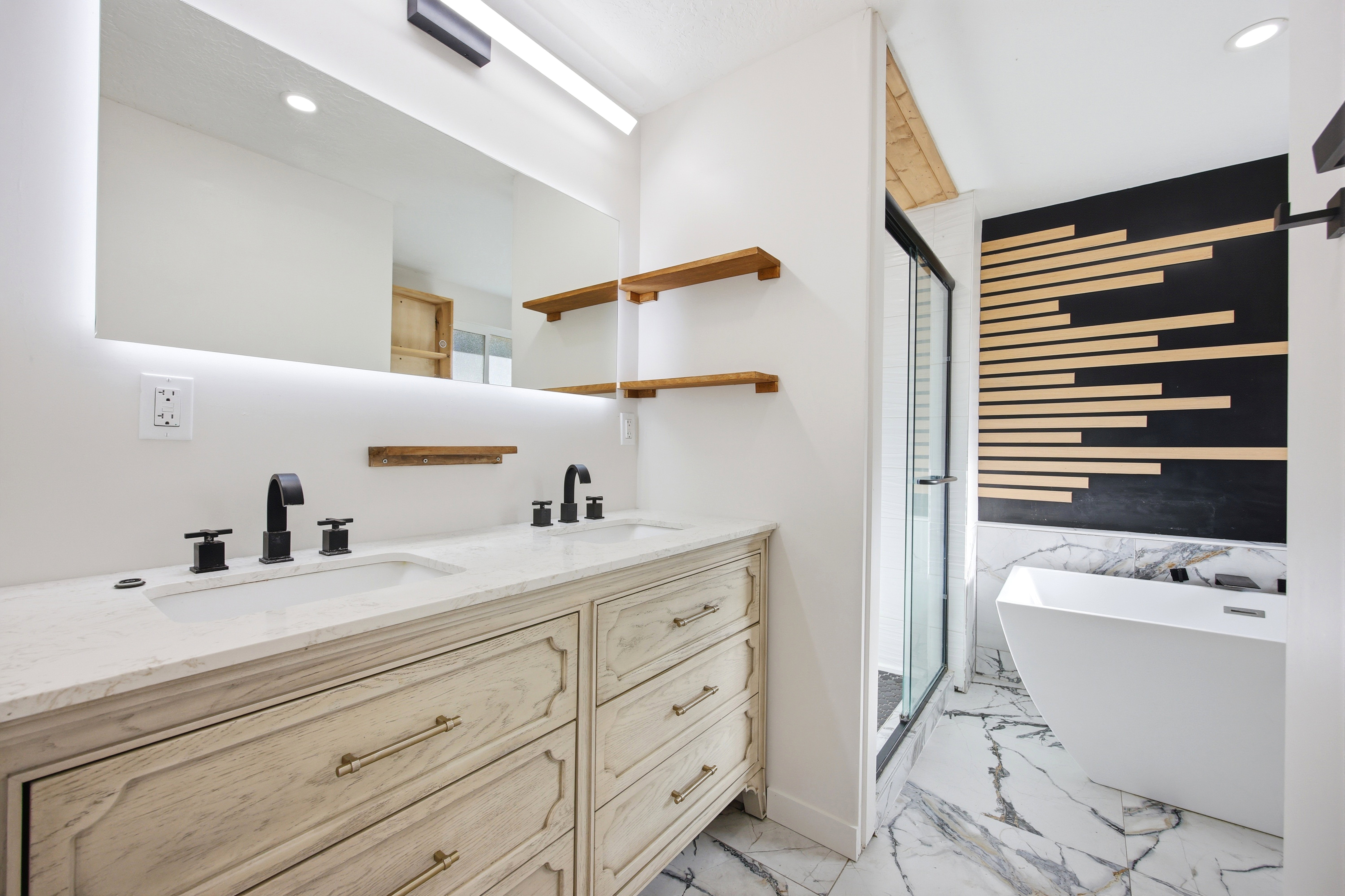 Bathroom featuring a double vanity with stone countertop, undermount sinks, and matte black fixtures