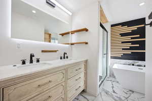 Bathroom featuring a double vanity with stone countertop, undermount sinks, and matte black fixtures