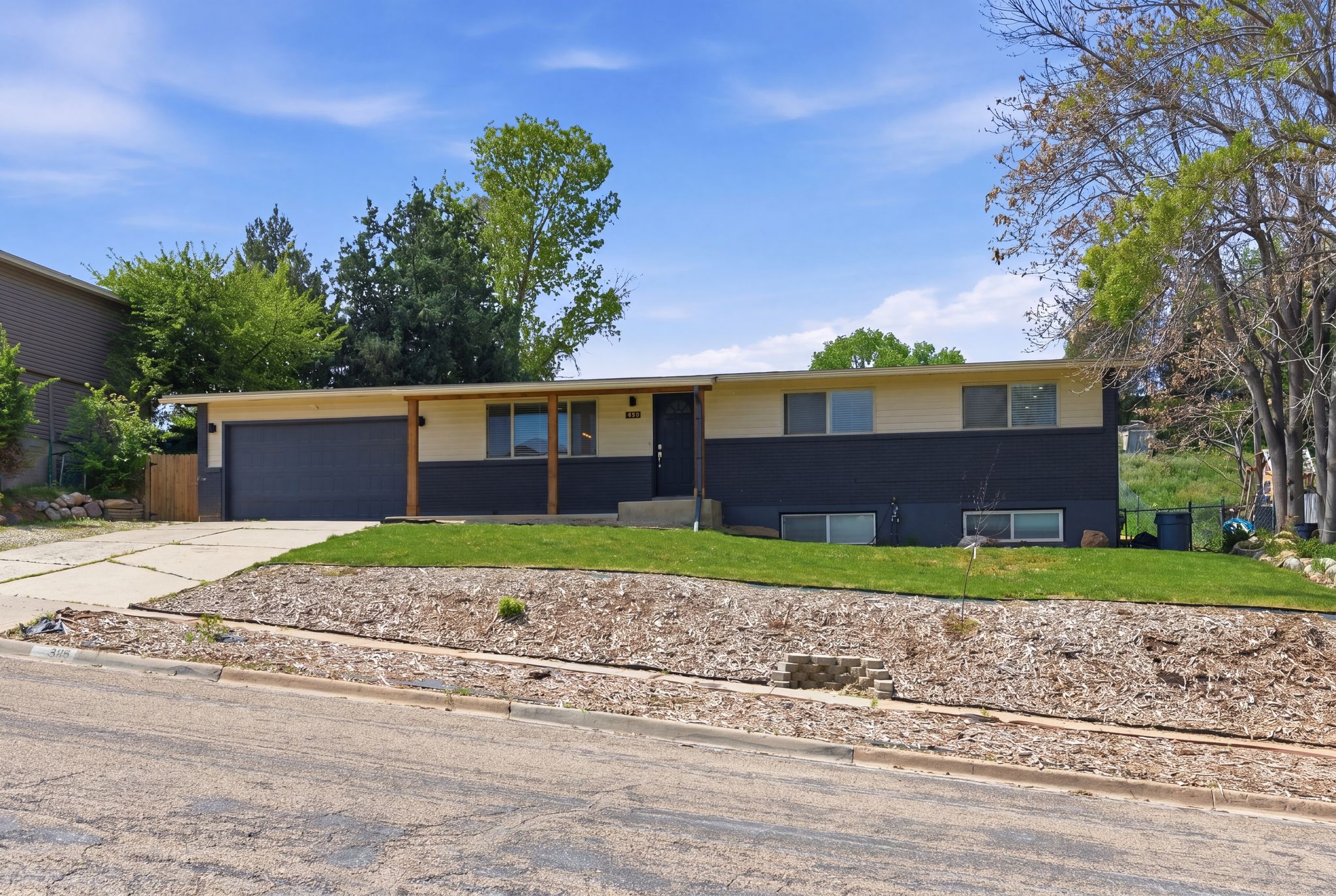 Ranch-style house featuring a front lawn, concrete driveway, and an attached garage