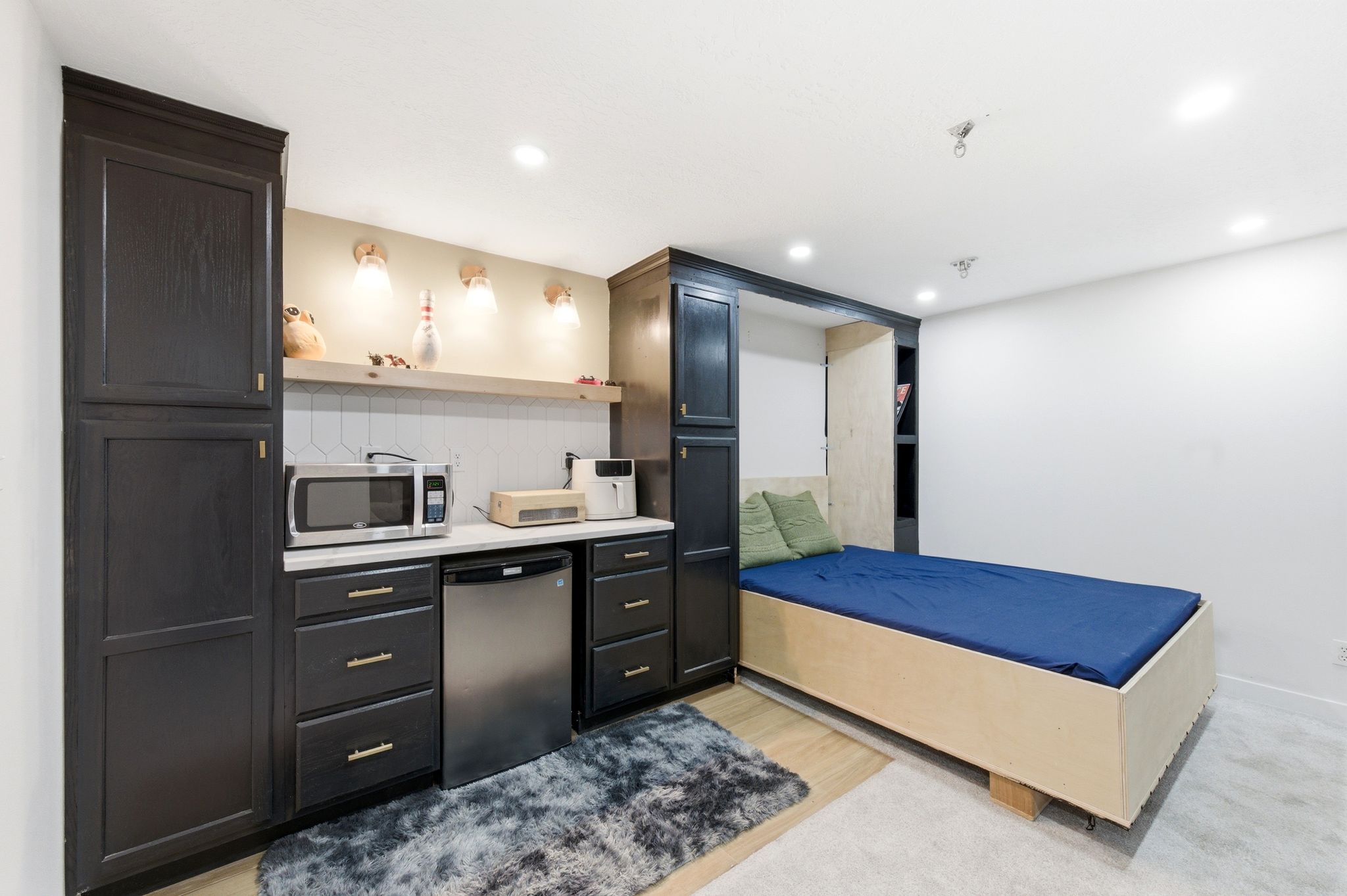 Kitchen with stainless steel appliances, light countertops, recessed lighting, open shelves, and backsplash