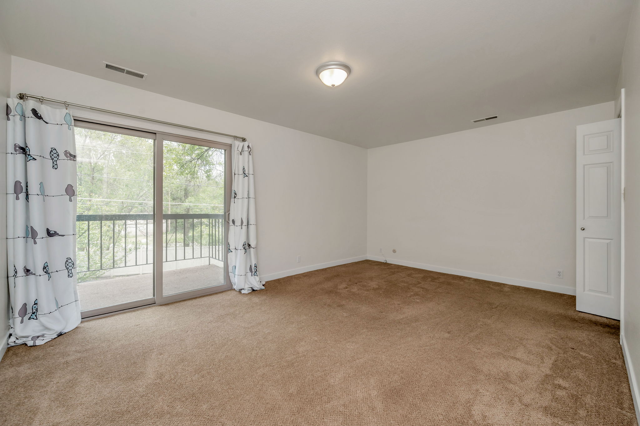 Primary suite/Master bedroom featuring light carpet and ensuite bathroom and walk-in closet.