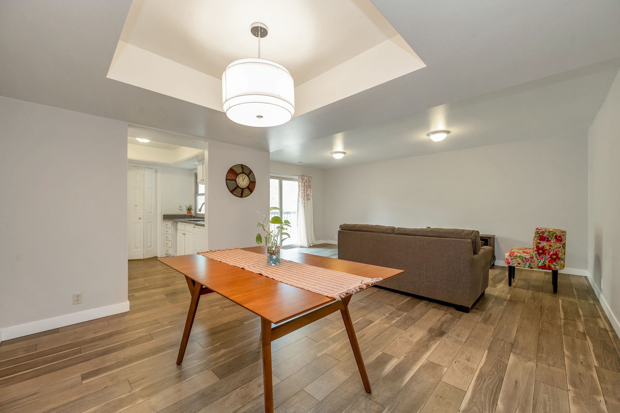 Dining area with a raised ceiling and laminate wood-style floor