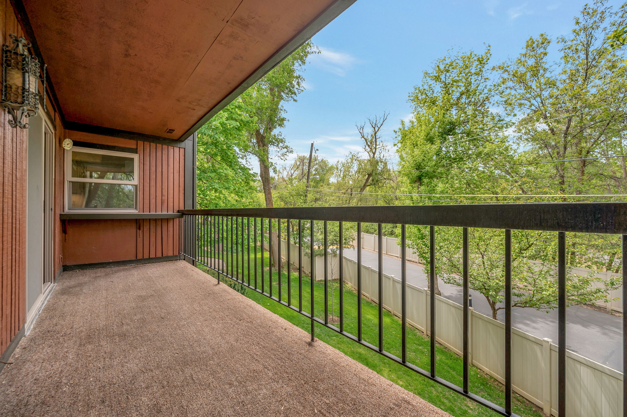 View from balcony. Surrounded by mature trees. Back side of building.