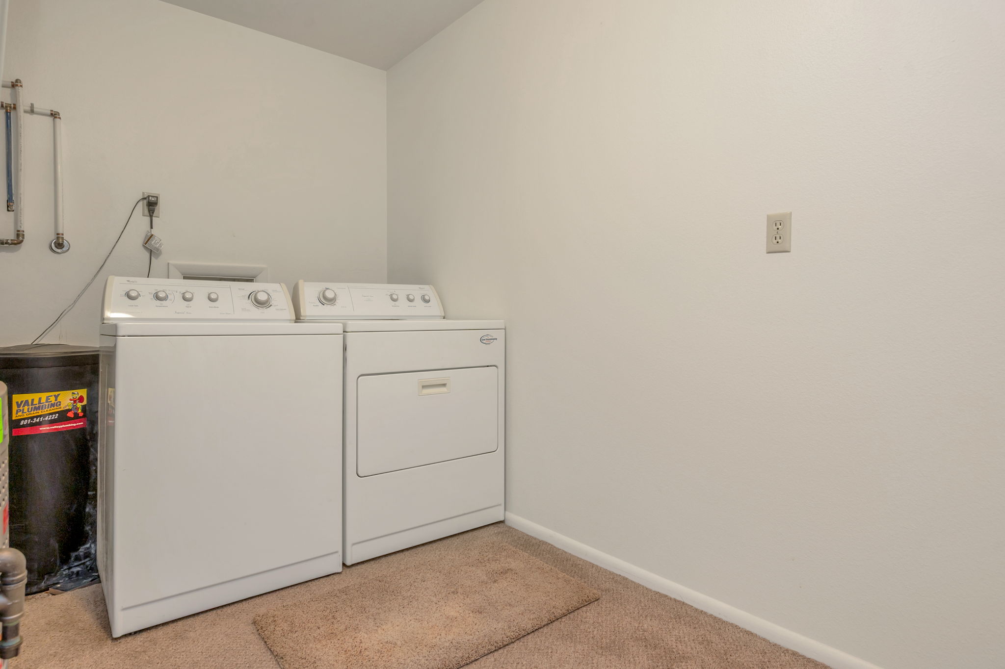 Laundry room with light carpet and washing machine and dryer