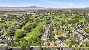 Aerial perspective of suburban area with a golf club and a water and mountain view