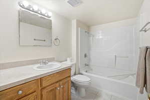 Bathroom featuring a vanity with wood-finish cabinetry, a single basin sink, and a light-colored countertop