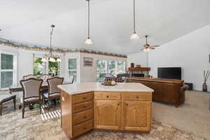 Kitchen island featuring wood cabinetry with drawers and storage, and a light-toned countertop