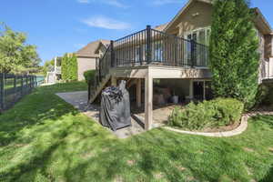 Back of house featuring a deck, stucco siding, and a patio area