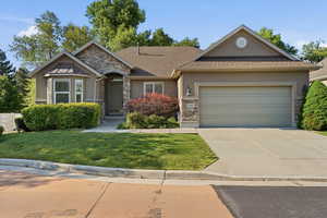 Stucco and stone facade home featuring a two-car garage, bay window, and arched entry