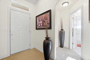 Entryway featuring a white paneled door with transom window, tile flooring, and light-toned walls