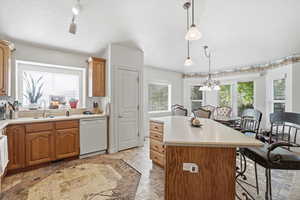Kitchen with wood-finish cabinetry, light countertops, and a white sink