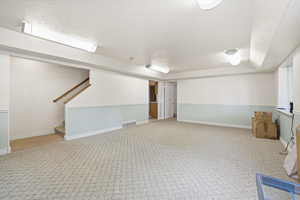Expansive room featuring patterned carpeting, two-tone wall treatment, and recessed lighting