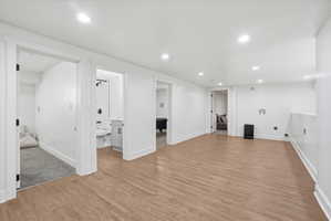 Finished below grade living room with light wood finished floors and recessed lighting
