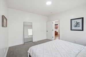 Bedroom featuring dark carpet and baseboards