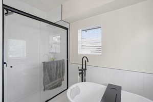 Full bathroom featuring a stall shower and a freestanding tub