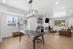 Office area featuring a glass covered fireplace, light finished floors, recessed lighting, and a textured ceiling