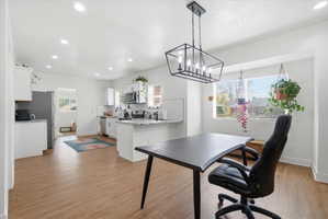 Dining area with light finished floors and recessed lighting