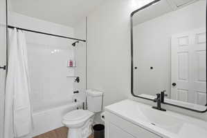 Full bathroom featuring vanity, shower / bath combo, a textured ceiling