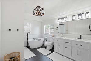 Bathroom with double vanity, a freestanding tub, wainscoting