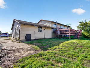 Back of property featuring a yard and a deck