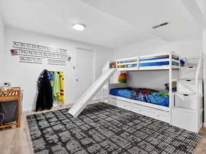 Bedroom featuring light wood finished floors and a textured ceiling