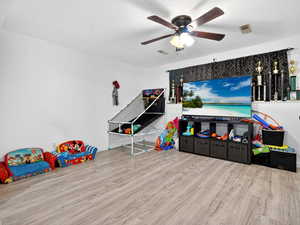 Game room with light wood-style floors and ceiling fan