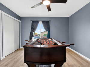 Game room featuring light wood finished floors and a ceiling fan
