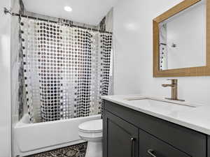Full bath with vanity, shower / bath combo, and recessed lighting