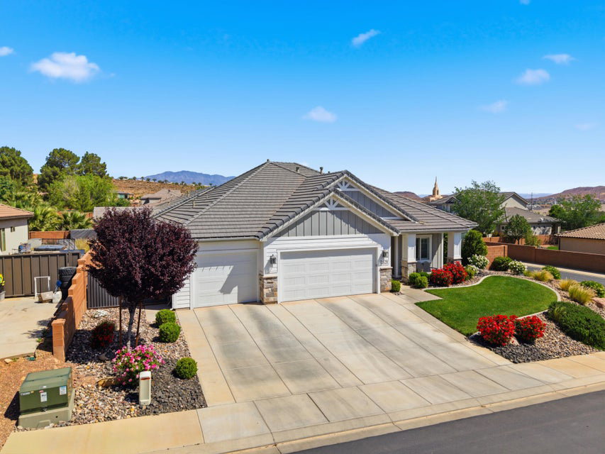 View of front of property with a garage, board and batten siding, stone siding, concrete driveway, and a mountain view