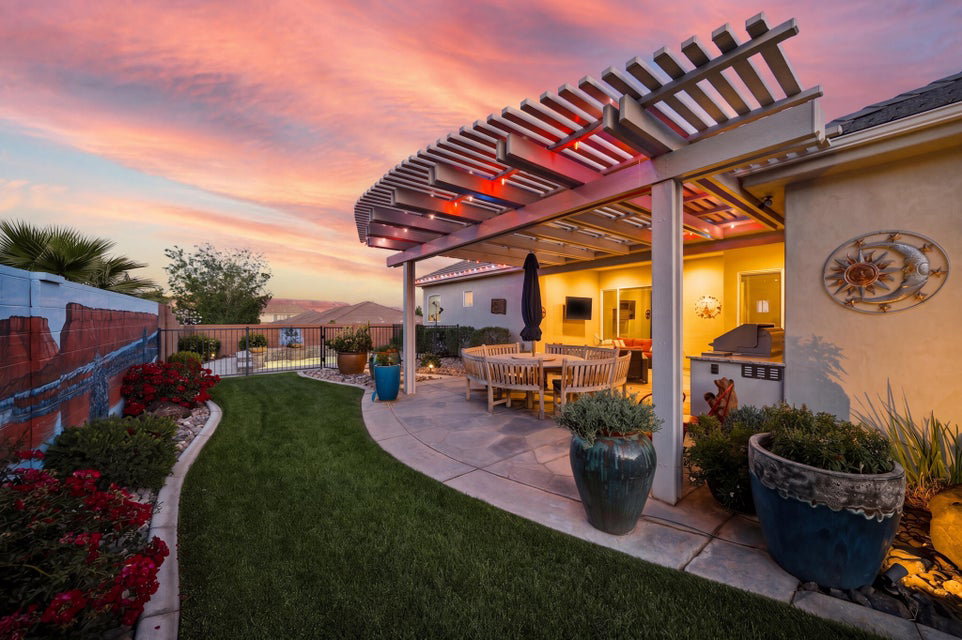 Yard at dusk featuring a patio, a fenced backyard, a pergola, and outdoor dining area